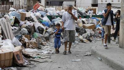 Residents cover their noses as they walk past piled up garbage in a street in Beirut on August 26, 2015. Mohamed Azakir / Reuters