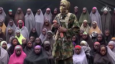 A video grab taken from a video released by Boko Haram showing a fighter in front of girls allegedly kidnapped from Chibok village in Nigeria in April 2014 (AFP / HO)