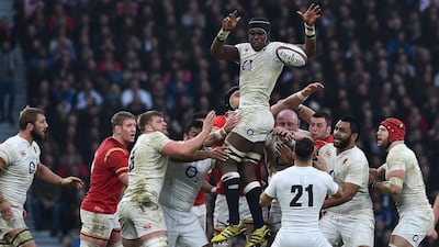 England's Maro Itoje, top, offloads the ball to England's Danny Care after winning a line out during the Six Nations international rugby union match between England and Wales at Twickenham in south west London on March 12, 2016. / AFP / BEN STANSALL