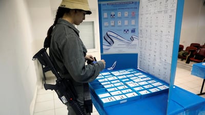 An Israeli border policewoman stands behind a mobile voting booth at a base in Beit Horon settlement. Reuters