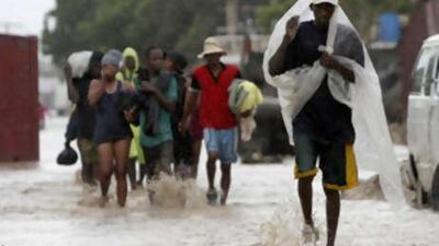 Residents wade through a flooded street after heavy rains in Gonaives, Haiti, Sunday, Sept. 7, 2008. Hurricane Ike damaged most of the homes on Grand Turk island as it roared onto the Bahamas, raked Haiti's flooded cities with rain and threatened the Florida Keys on its way to Cuba as a ferocious Category 4 storm Sunday.