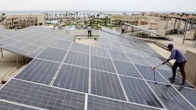 A worker cleans solar cells on the rooftop of a hotel in Sharm El Sheikh. Reuters