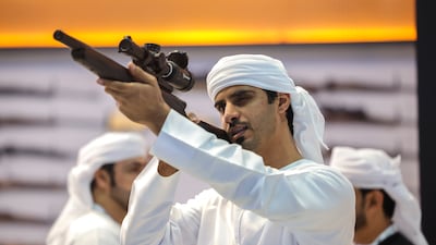 Visitors inspect arms on display at the exhibition. Victor Besa / The National