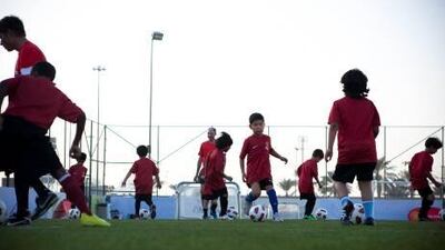 Children practice on a pitch next to the Dome on airport road during Manchester United Football School.