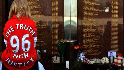 A child wears a jersey bearing the words "Justice for the 96" in front of the Hillsborough Memorial at Liverpool FC's Anfield football ground in Liverpool, England, on April 15, 2013, where supporters gathered for the 24th anniversary of the 1989 Hillsborough disaster where 96 Liverpool fans were crushed to death at Hillsborough Stadium. AFP