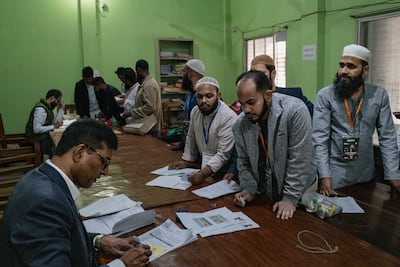 A polling officer provides a ballot to voters in the 13th general election on February 11, 2026 in Dhaka, Bangladesh. The election will determine the country's next government as millions of voters head to the polls amid heightened political tension and security concerns. Getty Images