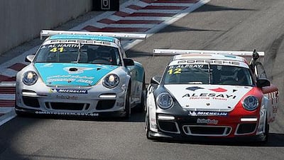 Bandar Alesayi, right, gives Ahmad Al HArthy the thumbs up after the Omani driver won the Porsche GT3 Cup Middle East race.