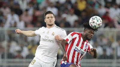 Real Madrid's Luka Jovic, left, fights for the ball with Atletico Madrid's Thomas Partey during the Spanish Super Cup Final soccer match between Real Madrid and Atletico Madrid at King Abdullah stadium in Jeddah, Saudi Arabia, Sunday, January12, 2020. AP Photo/Hassan Ammar