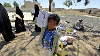 A young Yemeni carries part of his family's food rations provided by a local relief group, in Sanaa, Yemen. Yahya Arhab / EPA