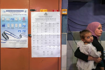 A woman and child at a polling station in Rahat. The election is expected to be followed by lengthy coalition talks. AFP