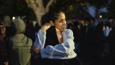 Mourners embrace at a vigil for victims of a shooting at a mosque in San Diego, California. Three people were killed and two teenage suspected gunmen died of self-inflicted gunshot wounds, police said. AFP