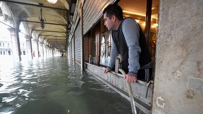 A man pumps water from a shop at the flooded St. Mark's Square, as high tide reaches peak, in Venice, Italy. REUTERS