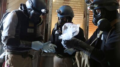 A UN chemical weapons expert holds a plastic bag containing samples from an alleged chemical weapons attack near Damascus, Syria. Reuters