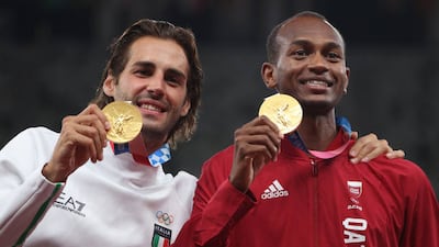 Joint gold medallists Mutaz Essa Barshim of Team Qatar and Gianmarco Tamberi of Team Italy celebrate on the podium during the medal ceremony for the Men's High Jump on day ten of the Tokyo 2020 Olympic Games. Getty