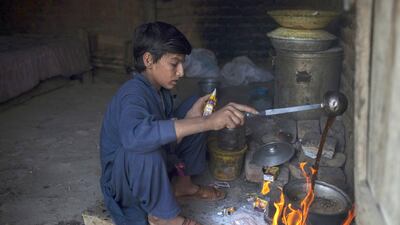 Samiullah, who says he is 14-years-old, prepares tea after finishing work at a coal mine in Choa Saidan Shah, Punjab. Nearly 60 per cent of Pakistan's working children are in Punjab province. Sara Farid / Reuters