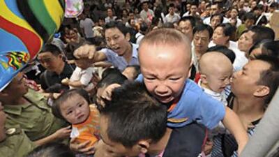 Security staff try to keep order as families with children who are undergoing medical checks for possible kidney stones wait to be seen at a hospital in Chongqing municipality on Sept 19 2008.