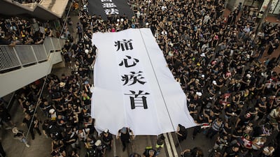 Protesters carry large banners as they march during a rally in Hong Kong on Sunday. Bloomberg