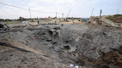 A Palestinian man walks past a crater on the ground following an Israeli air strike in Khan Younis. AFP