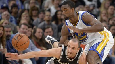 San Antonio Spurs' Manu Ginobili, bottom, of Argentina, chases the ball against Golden State Warriors' Harrison Barnes during the first half of an NBA basketball game, Sunday, April 10, 2016, in San Antonio. (AP Photo/Darren Abate)