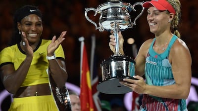 Angelique Kerber, right, is all smiles as she lifts the Australian Open trophy. Saeed Khan / AFP