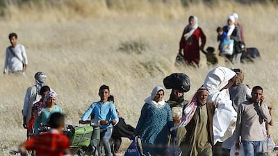 Syrian Kurds from Kobani walk towards the border fences as they are pictured from the Turkish border town of Suruc in Sanliurfa province, Turkey on June 25, 2015. ISIL fighters launched simultaneous attacks against the Syrian government and Kurdish militia overnight, moving back onto the offensive after losing ground in recent days to Kurdish-led forces near their de facto capital, Raqqa. Murad Sezer/Reuters