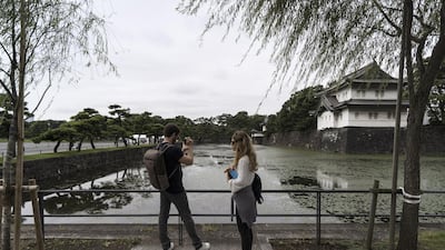 A couple stand in front of the Imperial Palace as Japan prepares for the enthronement of Emperor Naruhito, Tokyo, Japan. Getty