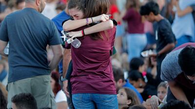 People hug one another before the start of a candlelight vigil for the victims of the Wednesday shooting at Marjory Stoneman Douglas High School, in Parkland, Flordia. Gerald Herbert / AP Photo