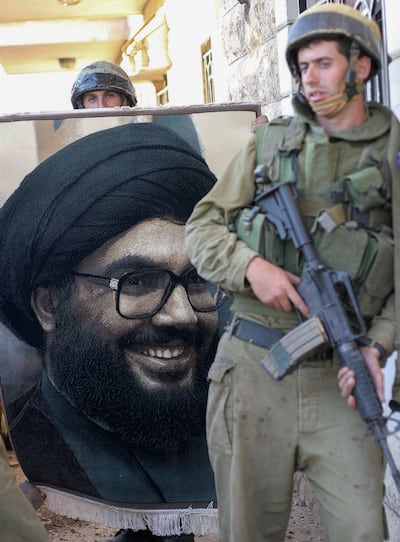Israeli soldiers stand by a portrait of Hassan Nasrallah, the former leader of Hezbollah, during the 2006 Lebanon invasion. AFP