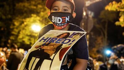A boy carries a sign with vice president-elect Kamala Harris at Black Lives Matter Plaza in Washington. Reuters