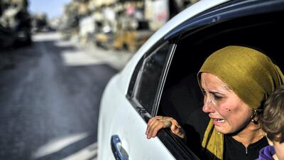 A woman cries as she looks at her house in Raqqa on October 20, 2017. AFP