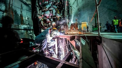A construction worker uses a metal saw. AFP