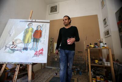 Iraqi refugee artist Saddam Jumaily stands next to his painting of he and his sister at his home workshop in Amman, Jordan. (Salah Malkawi for The National)