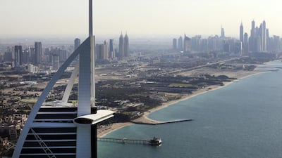 City skyscrapers stand near the coast beyond the tip of the Burj Al Arab luxury hotel, left, in Dubai. The seven-star hotel is a hot favourite among celebrities from around the world. Chris Ratcliffe / Bloomberg