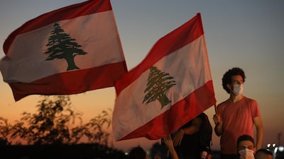 People wave Lebanese flags to mark the first anniversary of anti-government protests on October 17, 2020, in Beirut, Lebanon. Marwan Tahtah / Getty Images