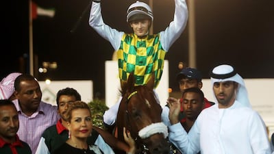 Harry Bentley, atop Thakif, celebrates after his National Day Cup win for trainer Majed Al Jahouri, right. Christopher Pike / The National