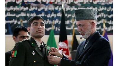 Hamid Karzai pins a medal on a newly graduated officer at the National Military Academy in Kabul yesterday.