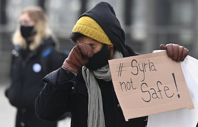 A demonstrator in Berlin wipes his face during a protest last week against deportations to Syria. AFP