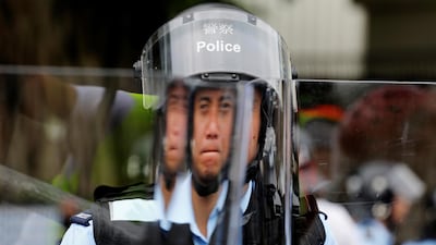 A police officer stands behind a riot shield. Reuters