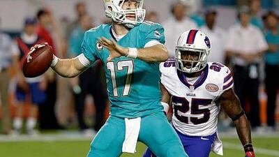 Miami Dolphins quarterback Ryan Tannehill, left, looks for an open receiver as Buffalo Bills strong safety Da'Norris Searcy closes in during the first half of their game on Thursday, Nov. 13, 2014, in Miami Gardens, Fla. AP Photo/Alan Diaz