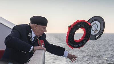 John Quinn, a Royal Marine who was a coxswain on a landing craft at Gold Beach throws a wreath into the sea.