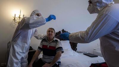 Healthcare workers look after a homeless coronavirus patient, in a hotel room in Prague. AFP