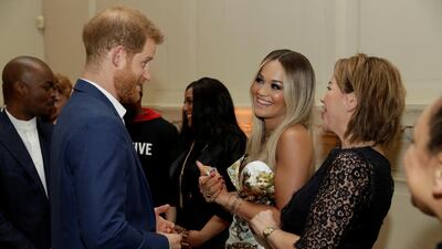 Prince Harry speaks with singer Rita Ora and her mum Vera Sahatciu during a reception before the concert. Reuters