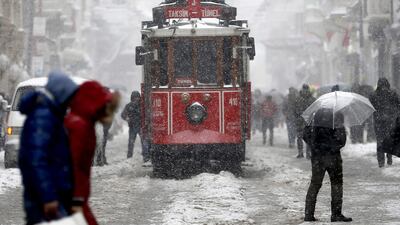People walk on Istiklal Street, while a tram passes, on a snowy day in Istanbul, Turkey. Sedat Suna / EPA