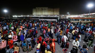 Migrant workers gather at a bus station to board buses to return to their villages after Delhi government ordered a six-day lockdown to limit the spread of the coronavirus disease. Reuters