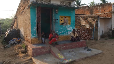 Jam Lachya sits outside his house with his wife and granddaughter. The fishermen is one of the last remaining 11 people in the village Podempeta which has become the victim of sea ingression and erosion.