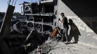 A Palestinian man clears rubble at the site of an Israeli strike on a house in Zawaida, central Gaza. Reuters