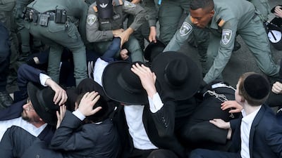 Police remove ultra-Orthodox Jews blocking a road in the central Israeli city of Bnei Brak in protest at plans to end their exemption from military service. AFP