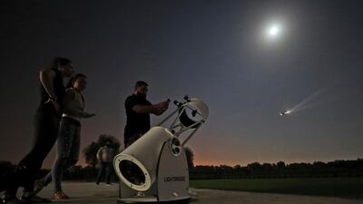 People watch a partial lunar eclipse through a telescope at the Al Thuraya Astronomy Centre in Dubai in July last year. Kamran Jebreili / AP
