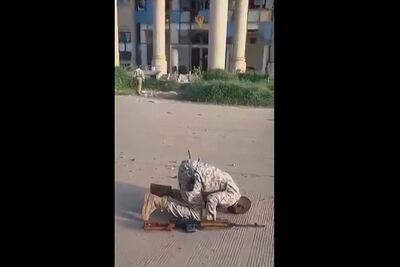 A Sudanese soldier offers a prayer of thanks after the army retook the presidential palace, in the background, in Khartoum from the paramilitary Rapid Support Forces. AFP