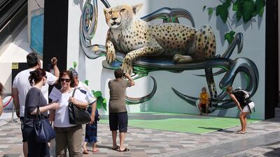 Visitors take photos of 3D street art at the Dubai Canvas festival held at The Walk at Jumeirah Beach Residence. Pawan Singh / The National